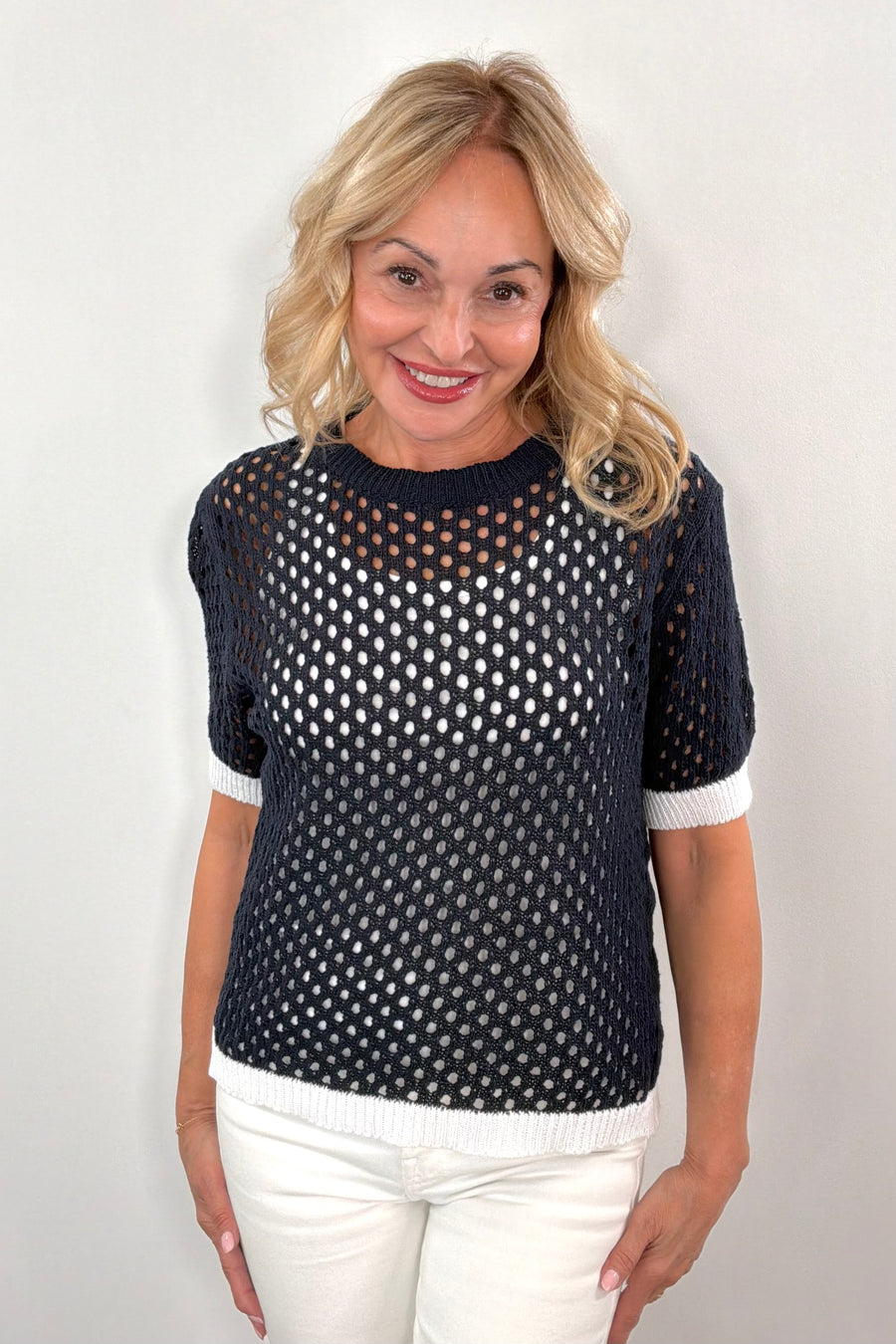 Woman wearing a navy open knit tee shirt
