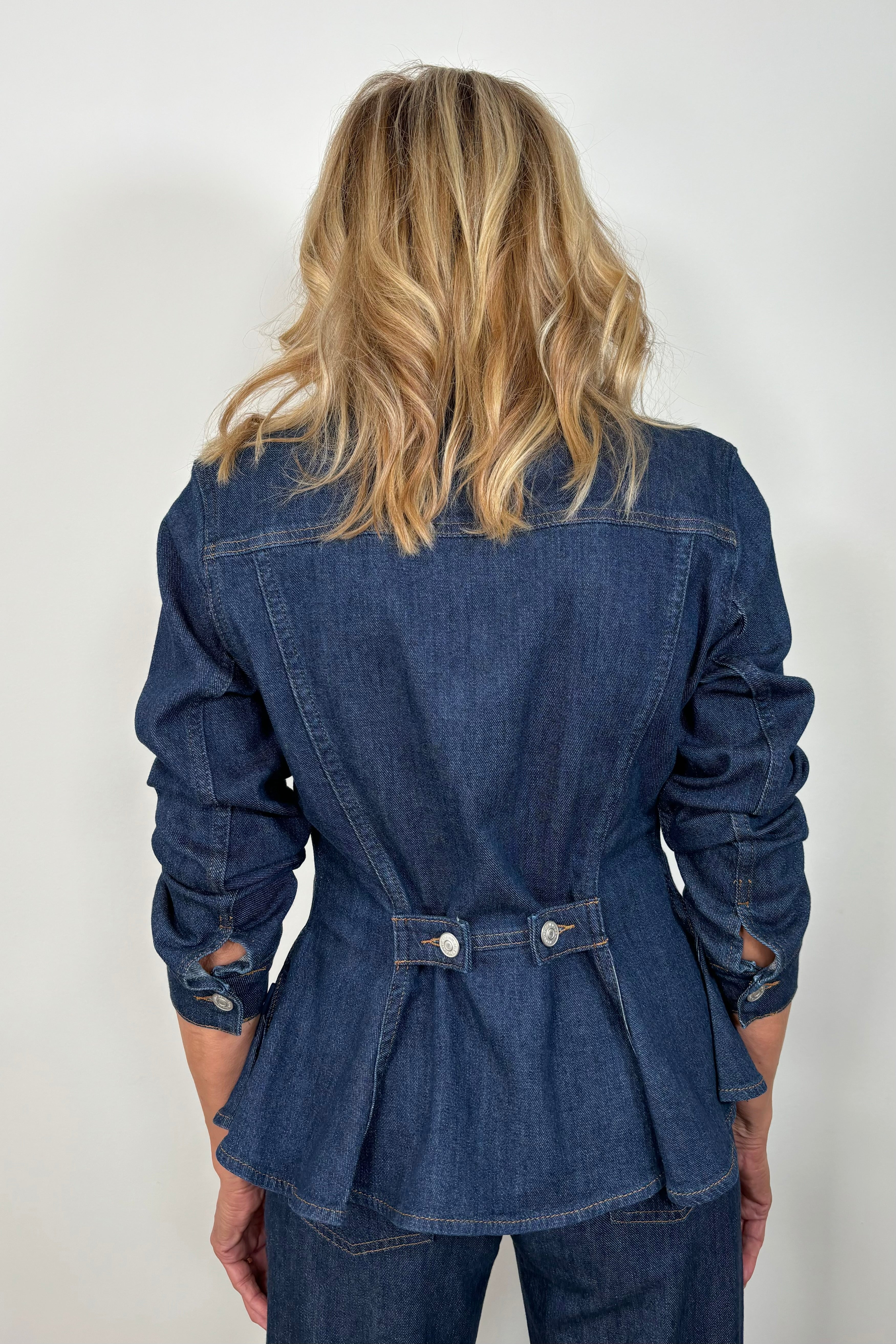 back view of woman wearing a fitted denim jacket