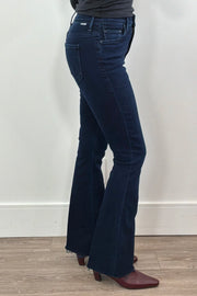 Person wearing frayed dark blue jeans 