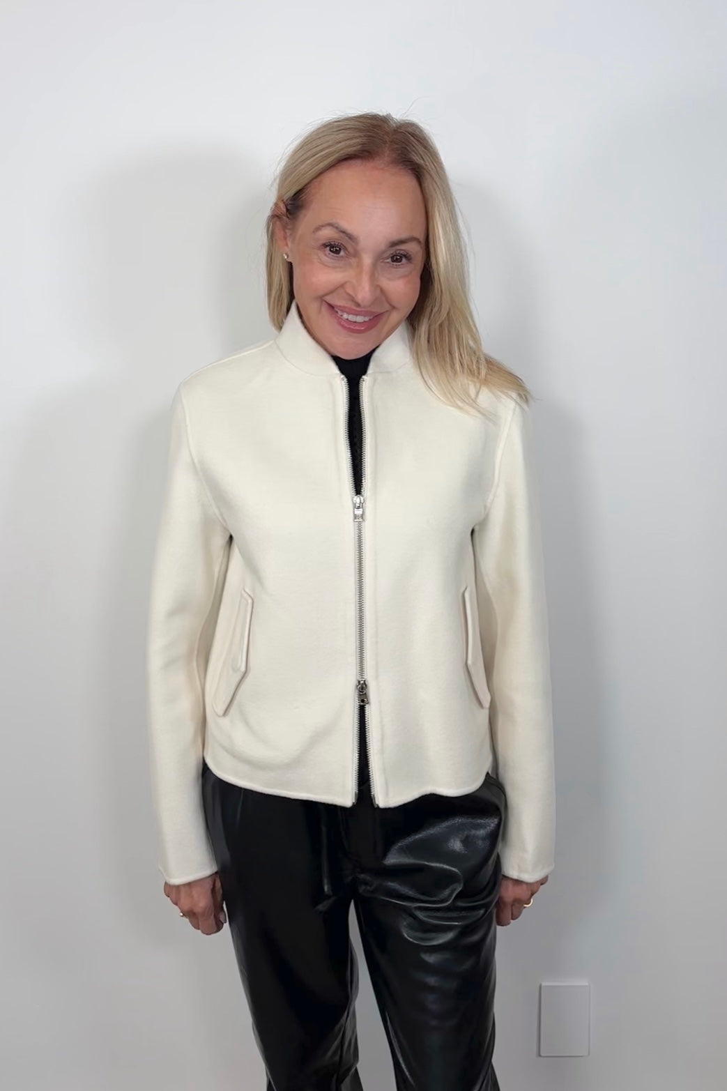 Front view of woman wearing a white double zipper silk bomber jacket 