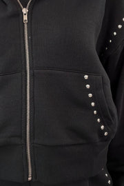 close-up of a black zip-up with studs along the seems