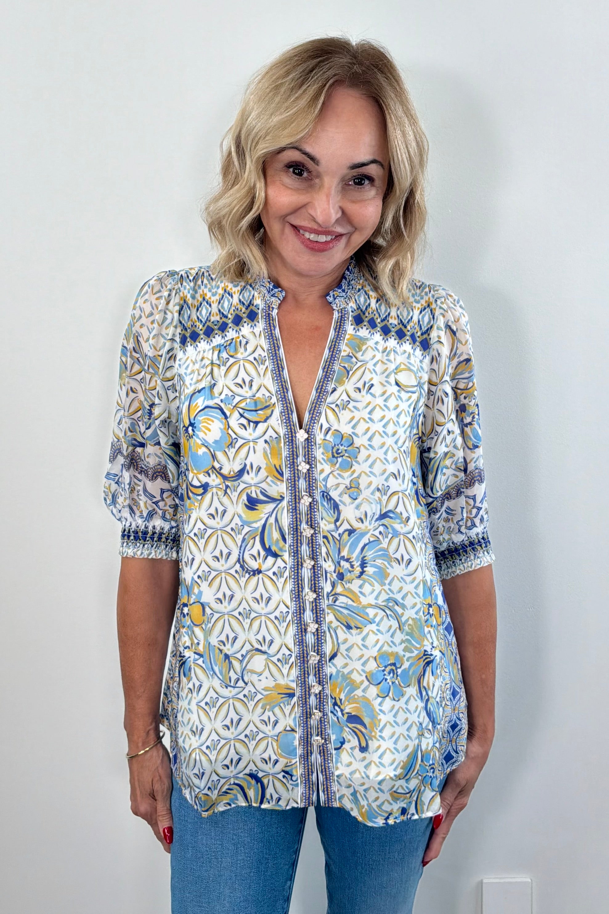 Woman wearing a patterned blue blouse 