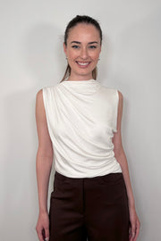 Front facing woman wearing a white rouched sleeveless top