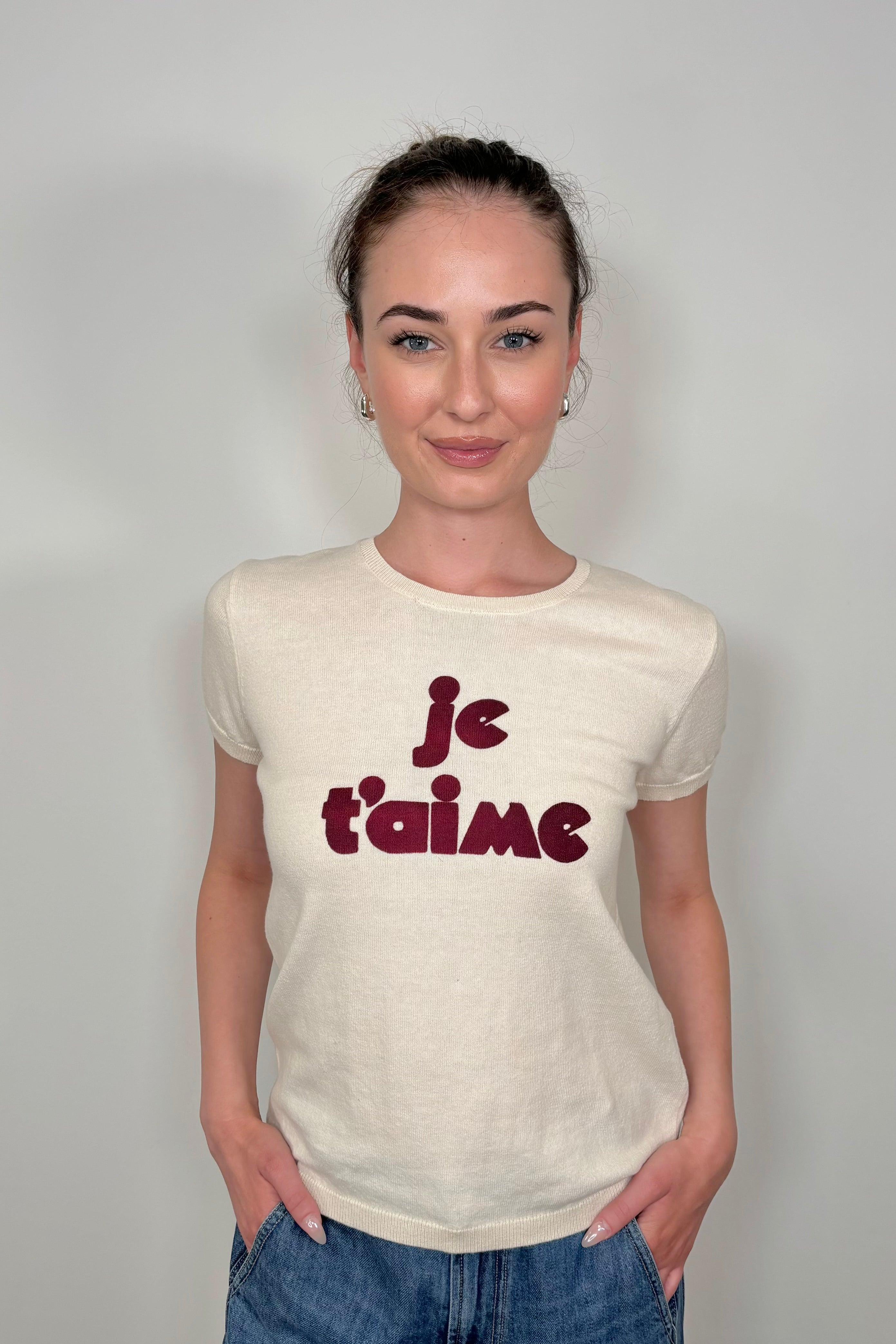Front view of woman wearing a knitted tee shirt with text on it