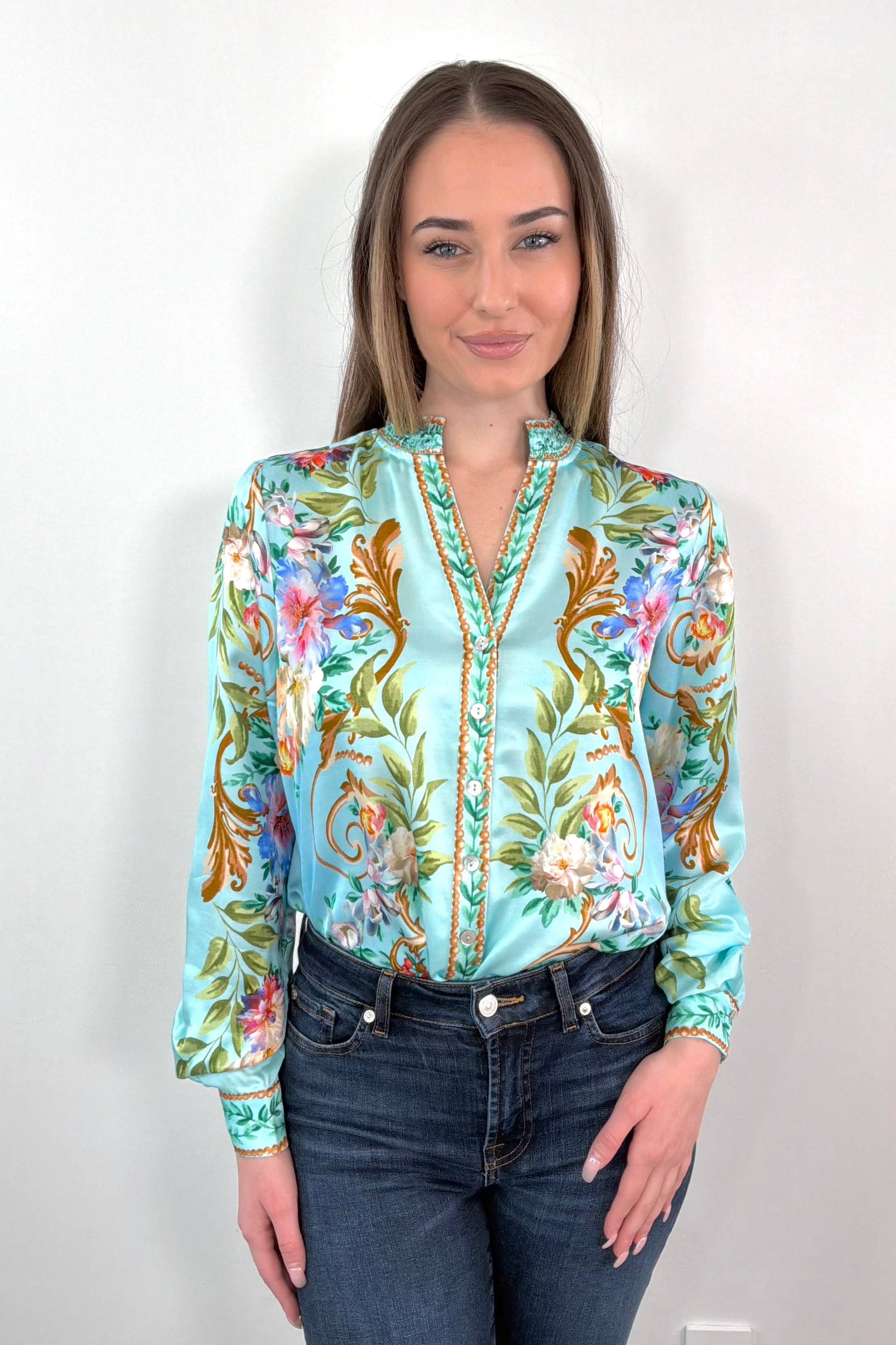 woman wearing a teal regency printed button down shirt tucked in