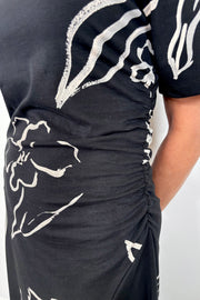 Black dress with white floral patterns on a plain background