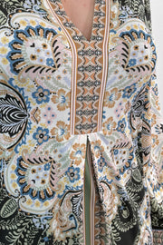 close-up of an ivory, green and black short long sleeve dress