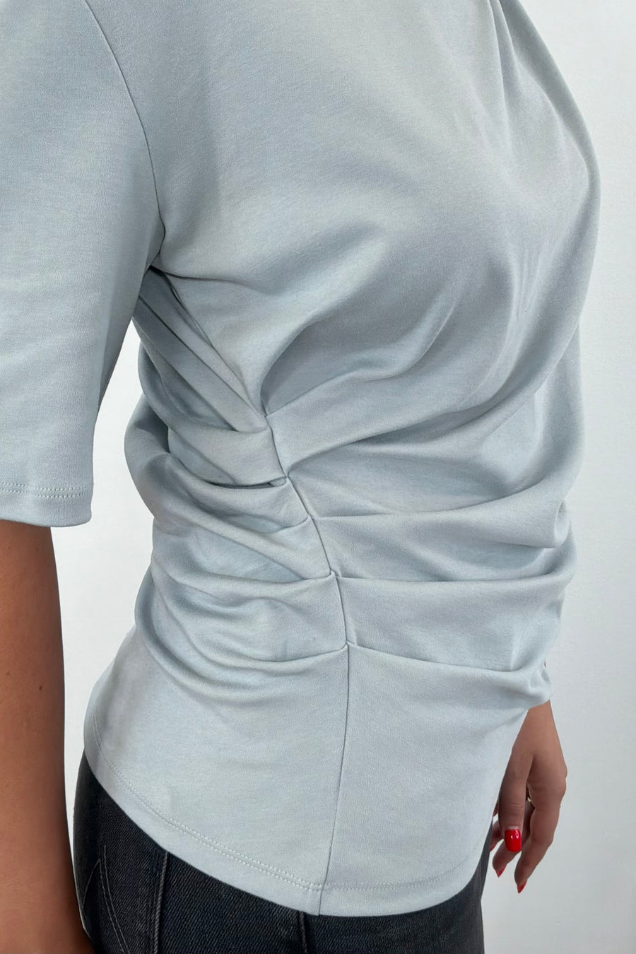 Woman wearing a blue gray t-shirt with twist detail