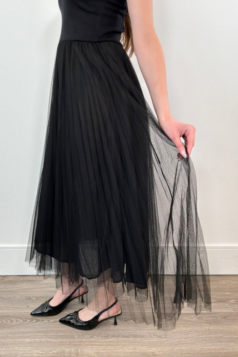 woman waring black sleeveless dress with a tulle skirt