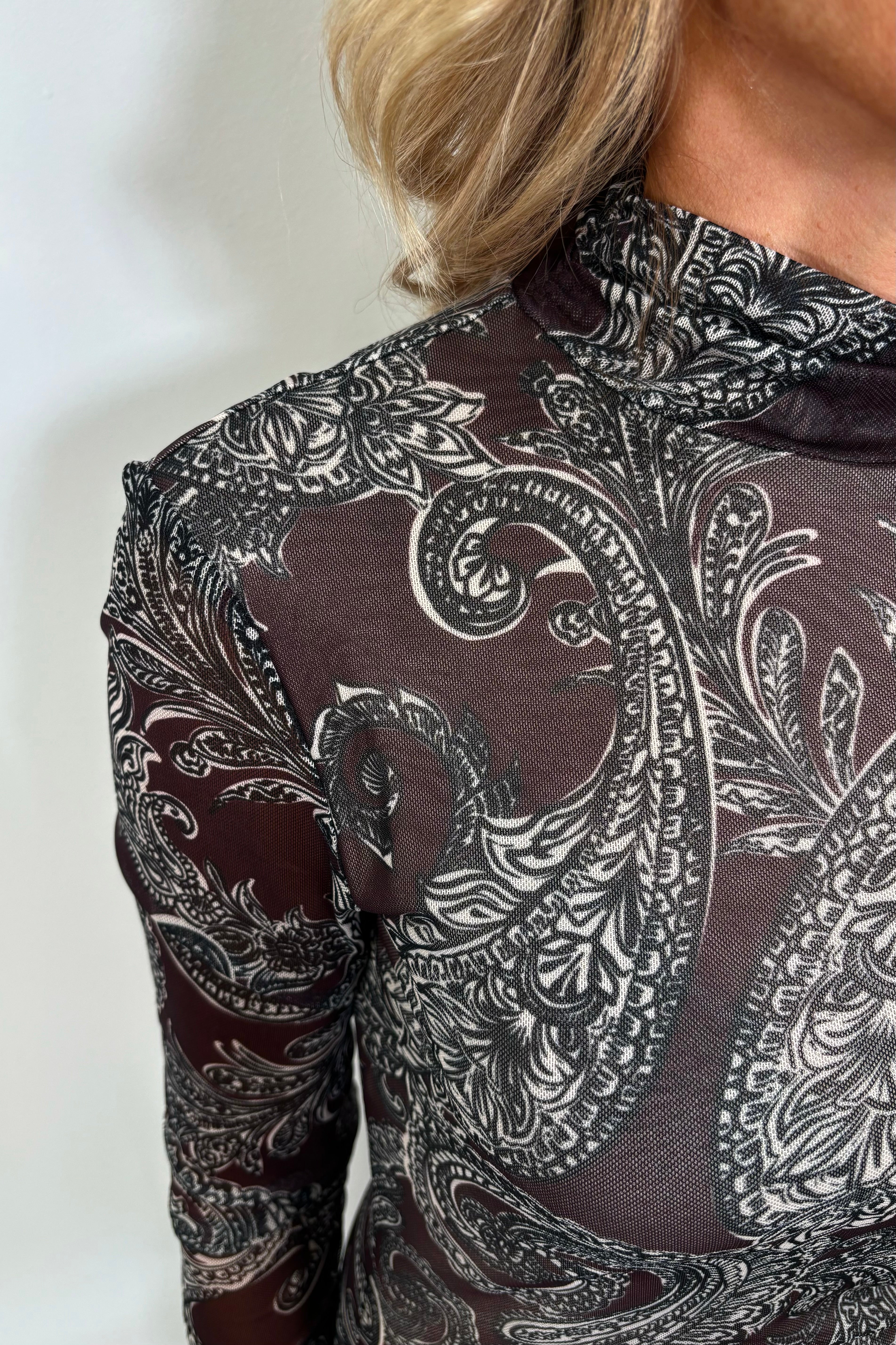 Close-up of the mock neck of a long sleeve mesh dress