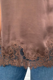 Woman wearing a brown lace-trimmed top