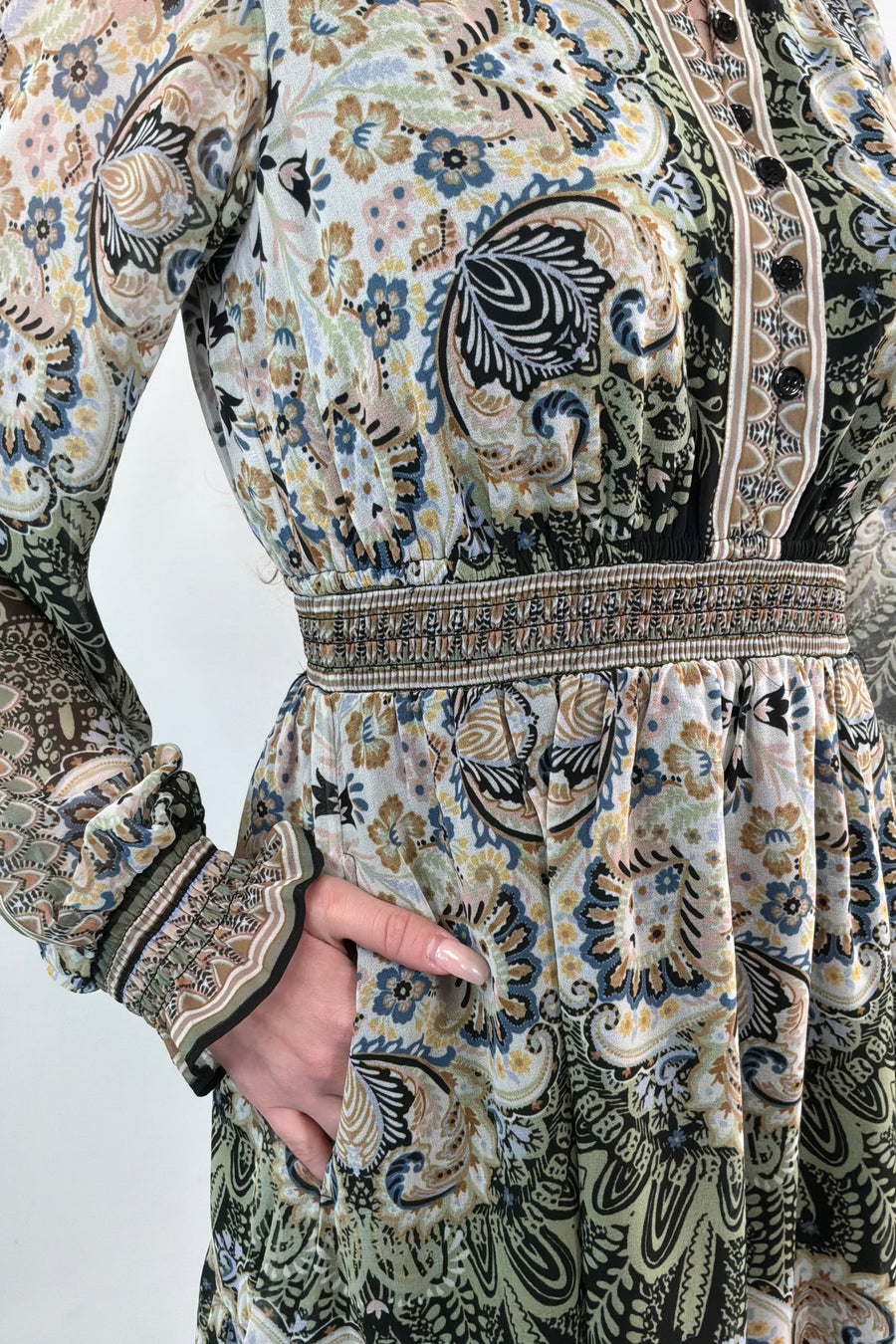 Close-up of an ivory, green and black short A-line long sleeve dress