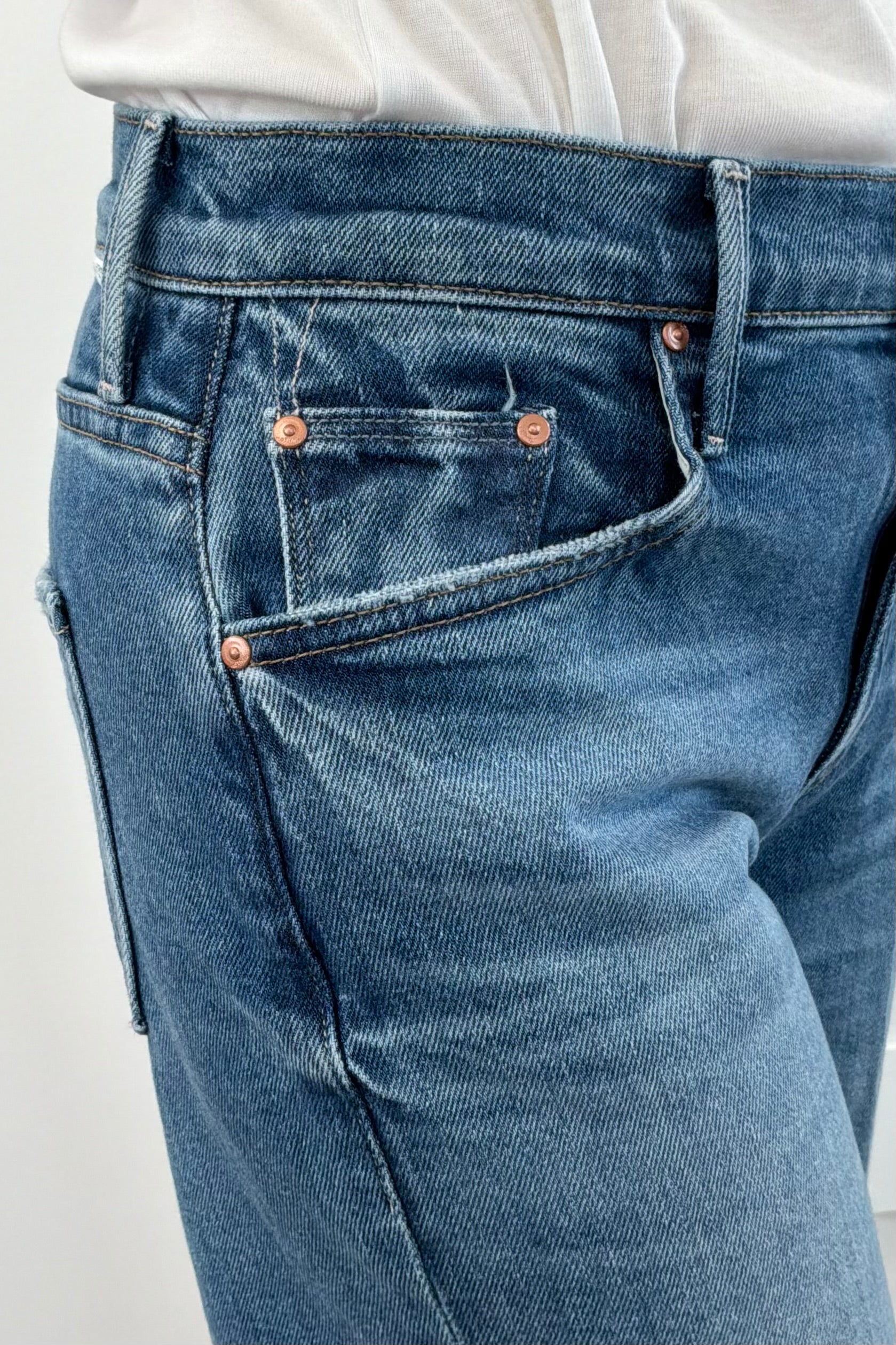 Close up of woman wearing wide leg mid rise washed blue denim
