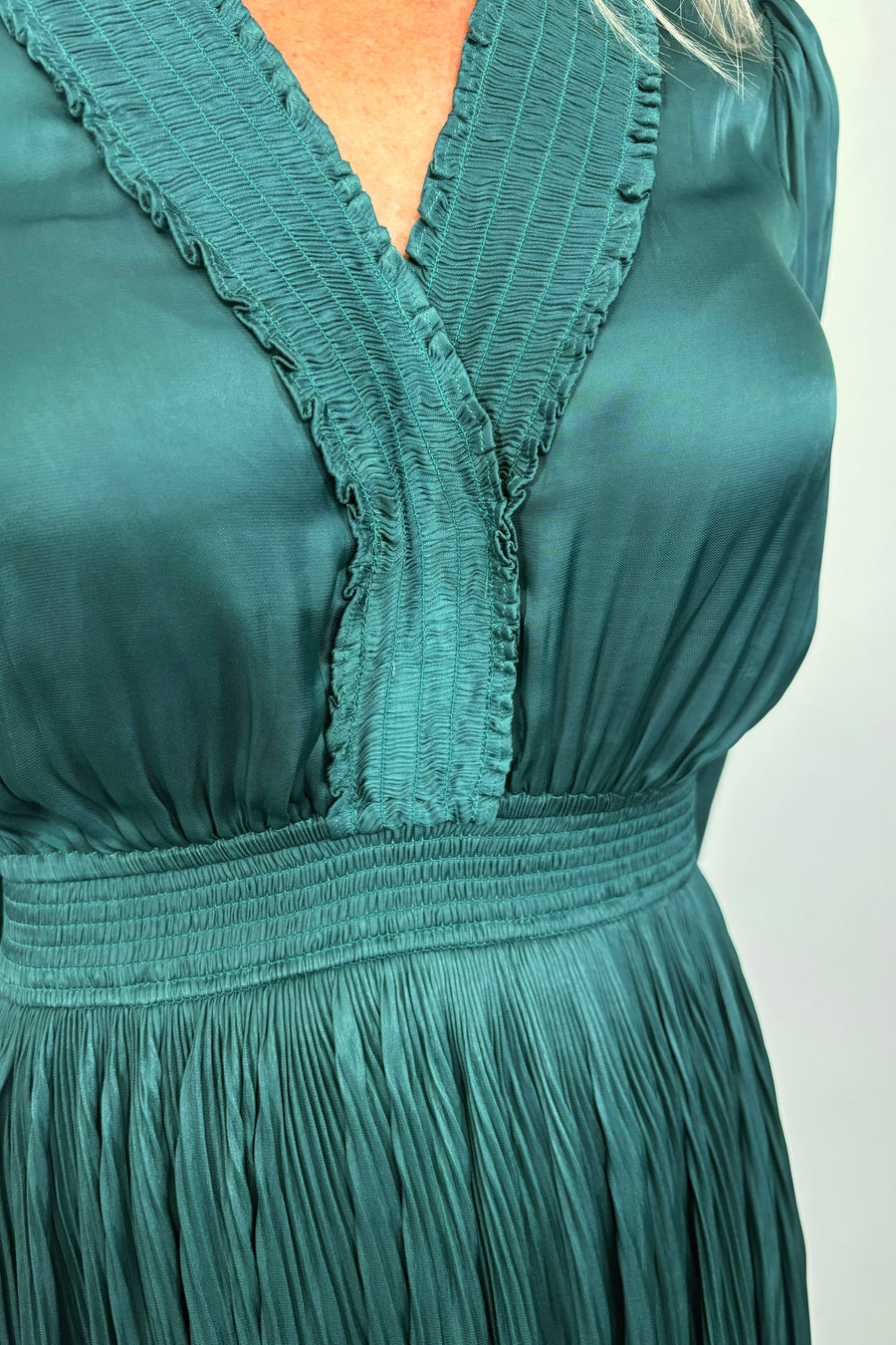 Close-up view of woman wearing a green maxi long sleeve silk dress