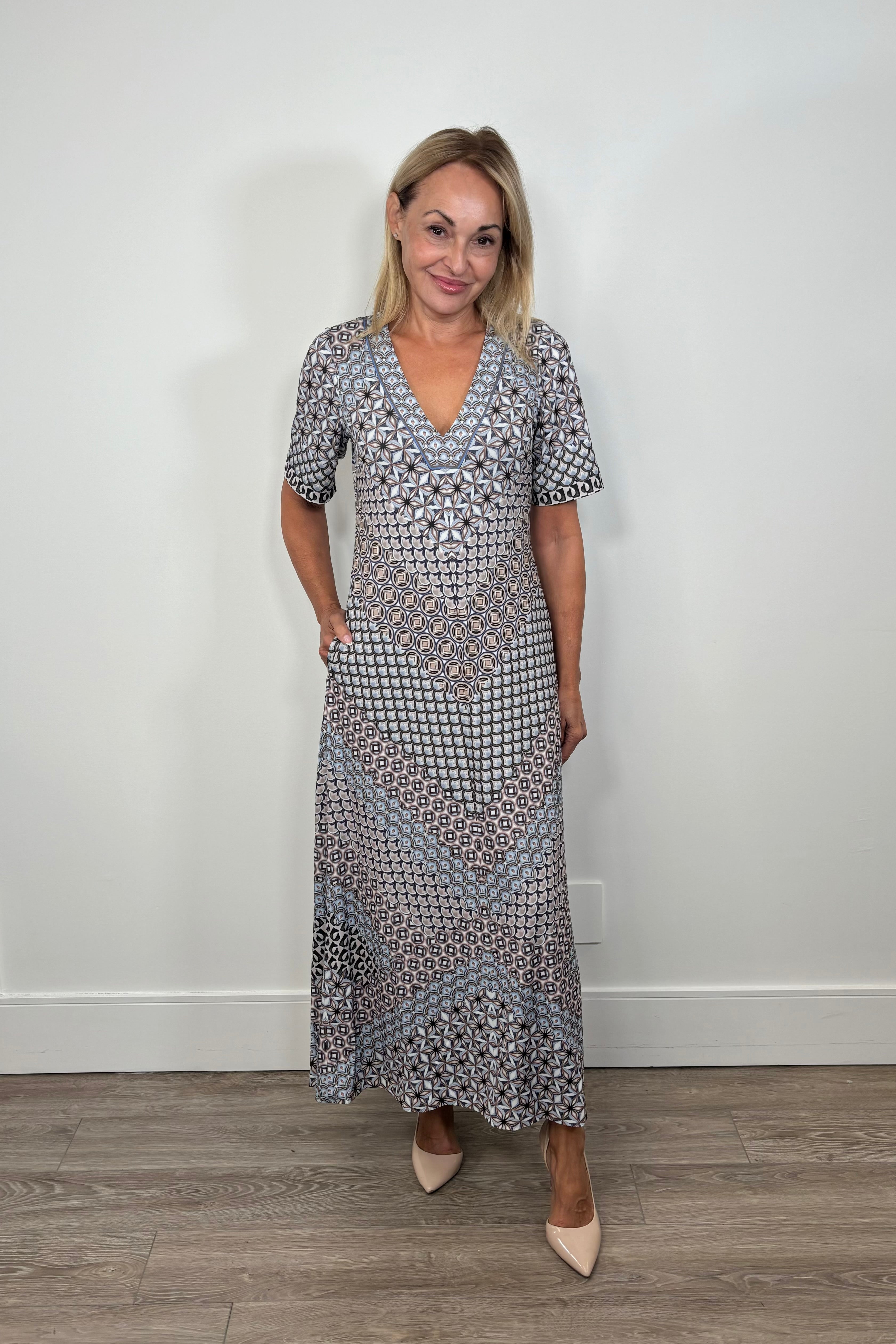 Front facing woman wearing a black and blue pattern jersey midi dress