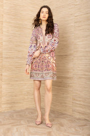 Front view of woman wearing a short, cuffed sleeve, v-neck, patterned dress