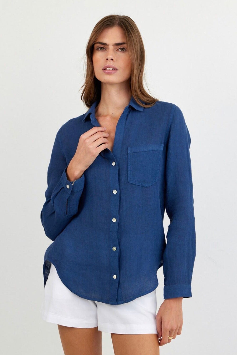 Woman wearing a dark blue linen button up with pocket on side chest