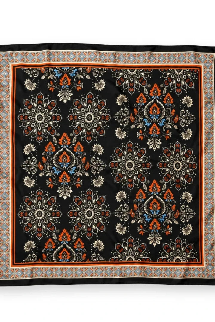 A square black scarf with an intricate floral and geometric pattern in orange, beige, and blue, finished with a solid black border.