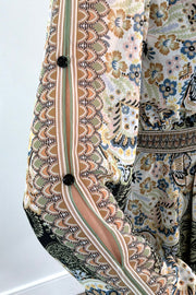 Close-up of an ivory, green and black short A-line long sleeve dress