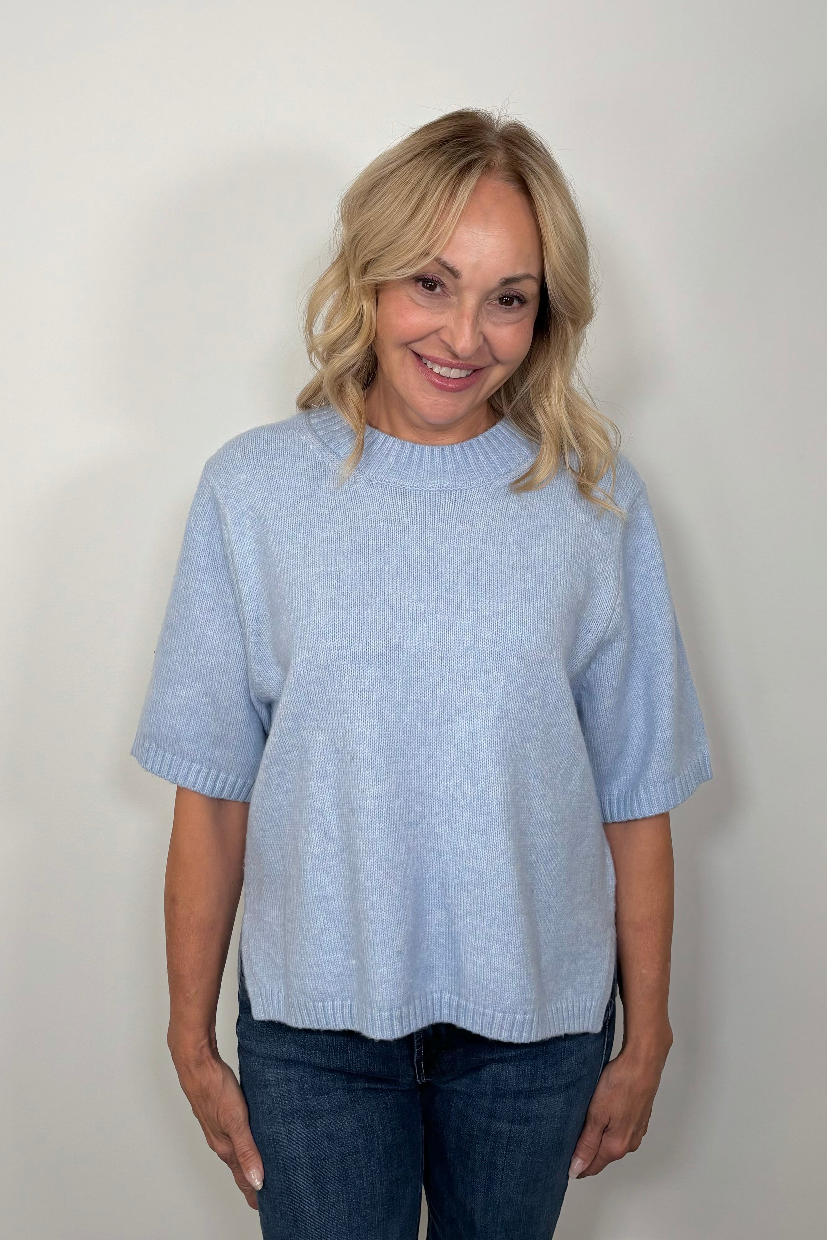 Front view of woman wearing a light blue half sleeve sweater