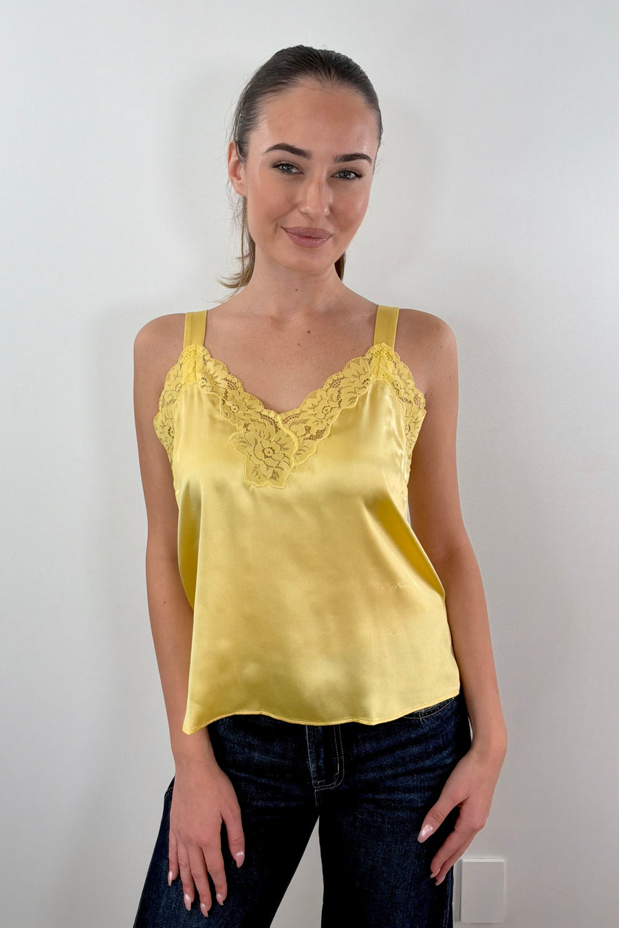 Woman wearing gold satin lace trim tank top