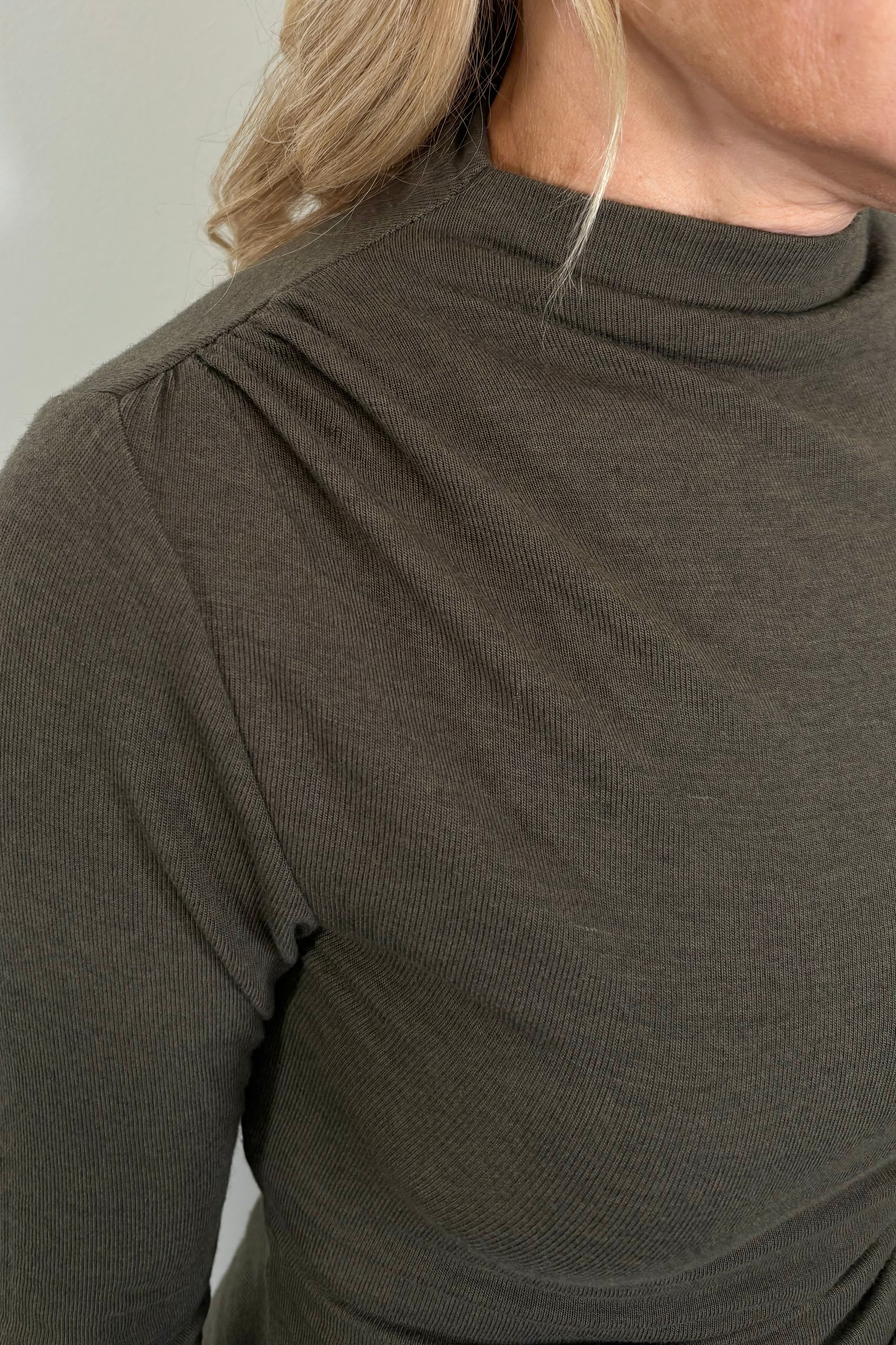 Close-up of a mock neck rouched long sleeve top