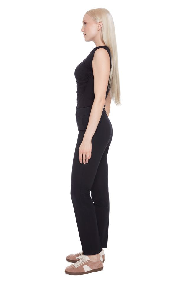 Side view of woman wearing a black sleeveless top and black compression pants 