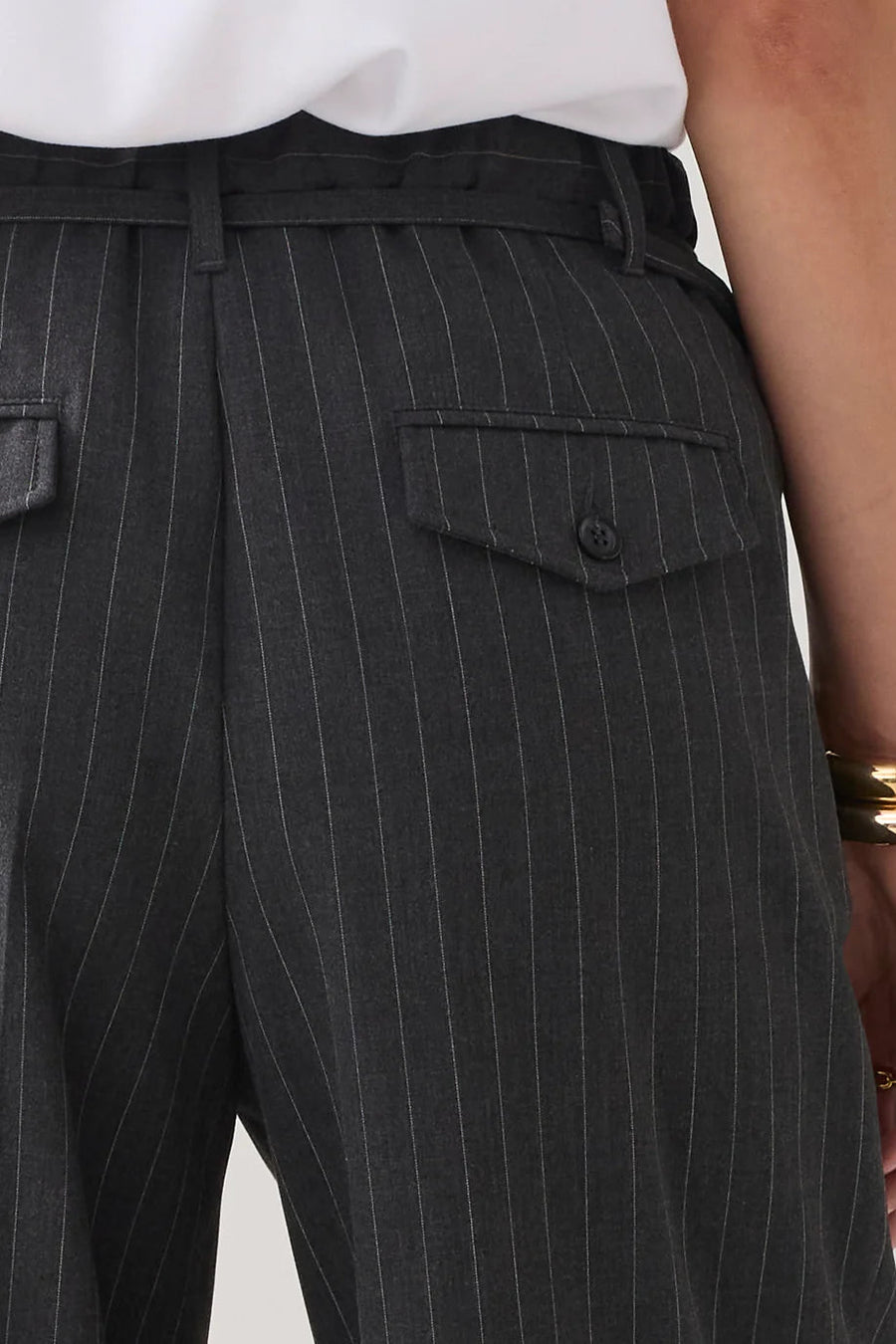 Gray pinstripe pants with a white shirt on a neutral background
