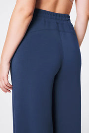 Navy blue pants worn by a person on a light gray background