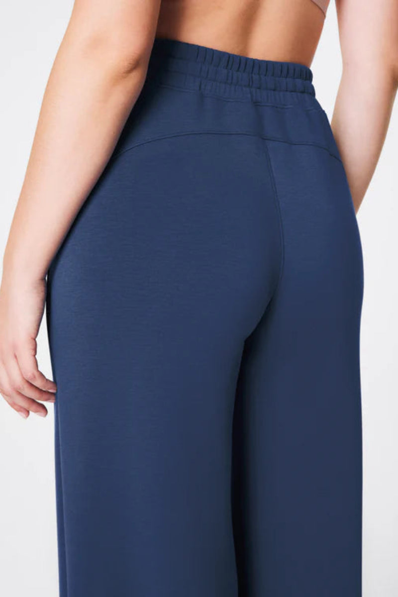 Navy blue pants worn by a person on a light gray background