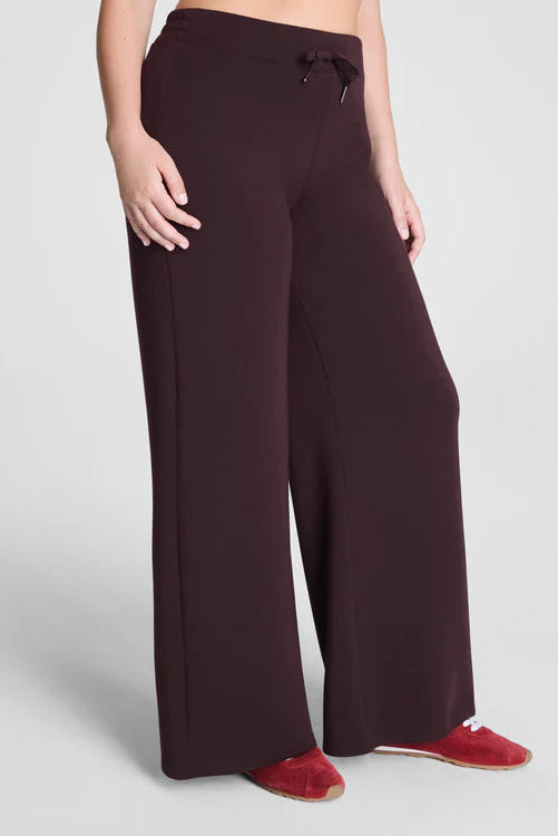 Brown wide-leg pants worn by a person on a light gray background