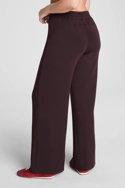 Brown wide-leg pants worn by a person on a light gray background