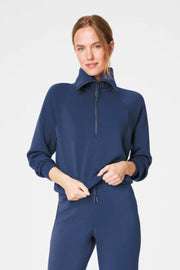 Woman wearing a navy blue outfit on a light gray background
