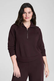 Woman wearing a brown half-zip sweatshirt 
