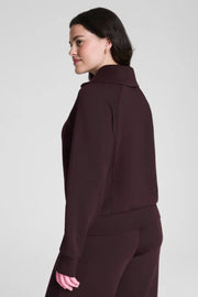 Woman wearing a dark brown sweat set on a light gray background