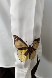 Close-up of the cuffed sleeve of a silk button up shirt