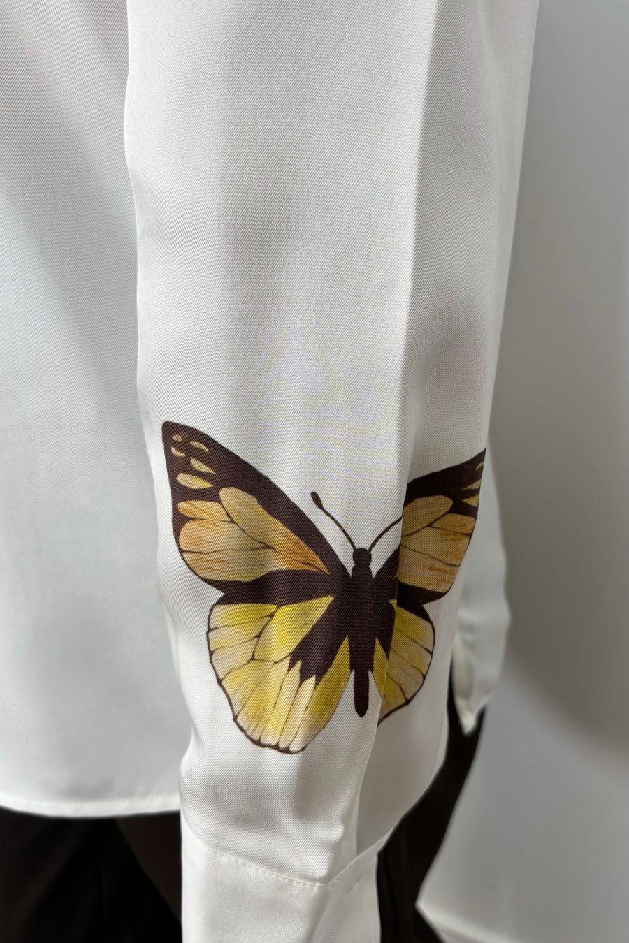 Close-up of the cuffed sleeve of a silk button up shirt