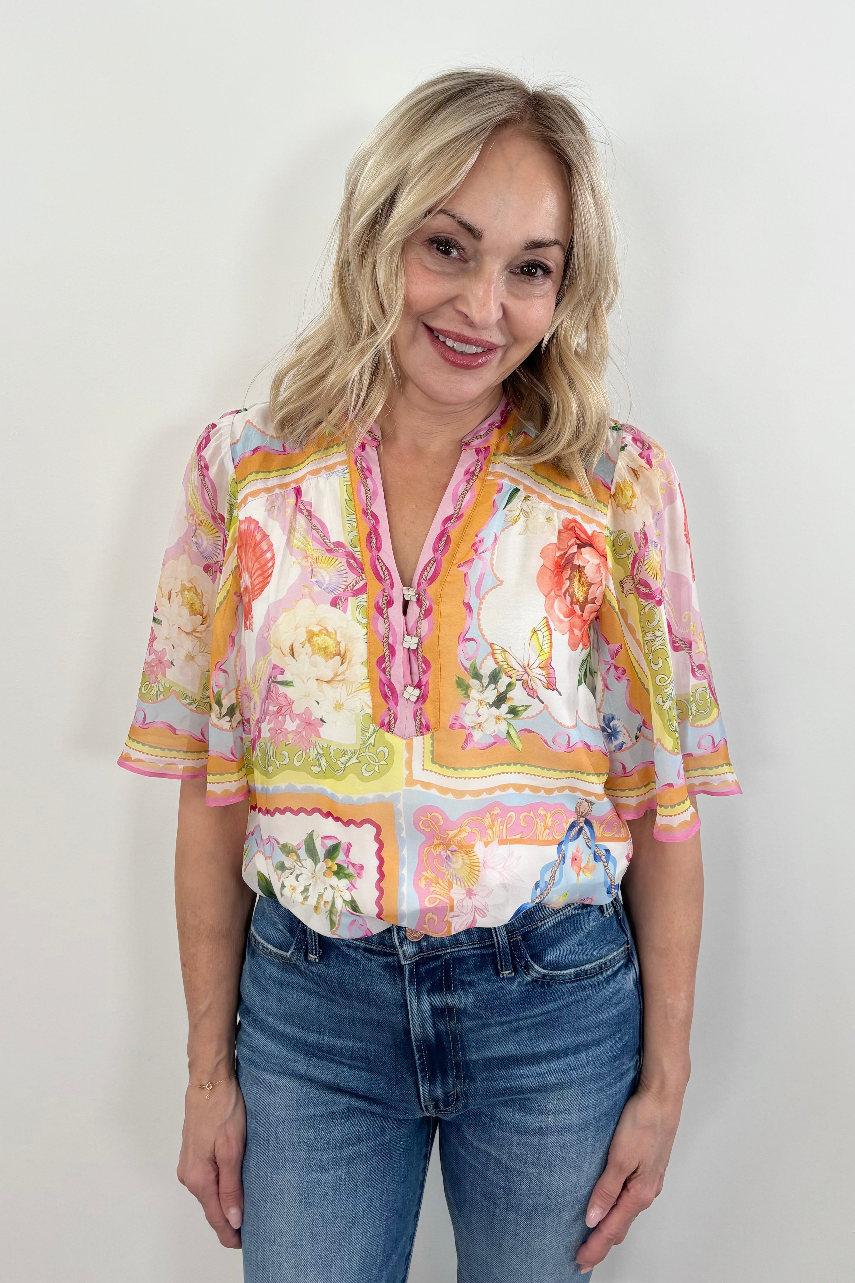 Woman wearing a warm colorful blouse with floral and butterfly print allover
