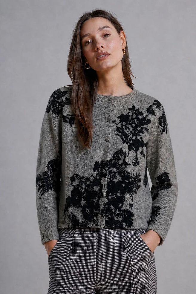 woman wearing grey cardigan with black floral designs 