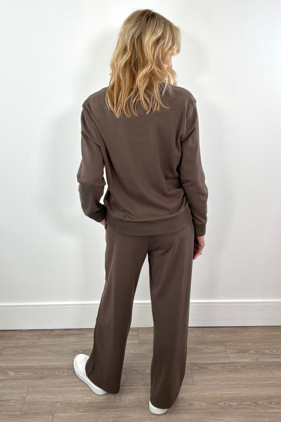 Woman wearing a brown v-neck pull on sweat top and a matching drawstring pant