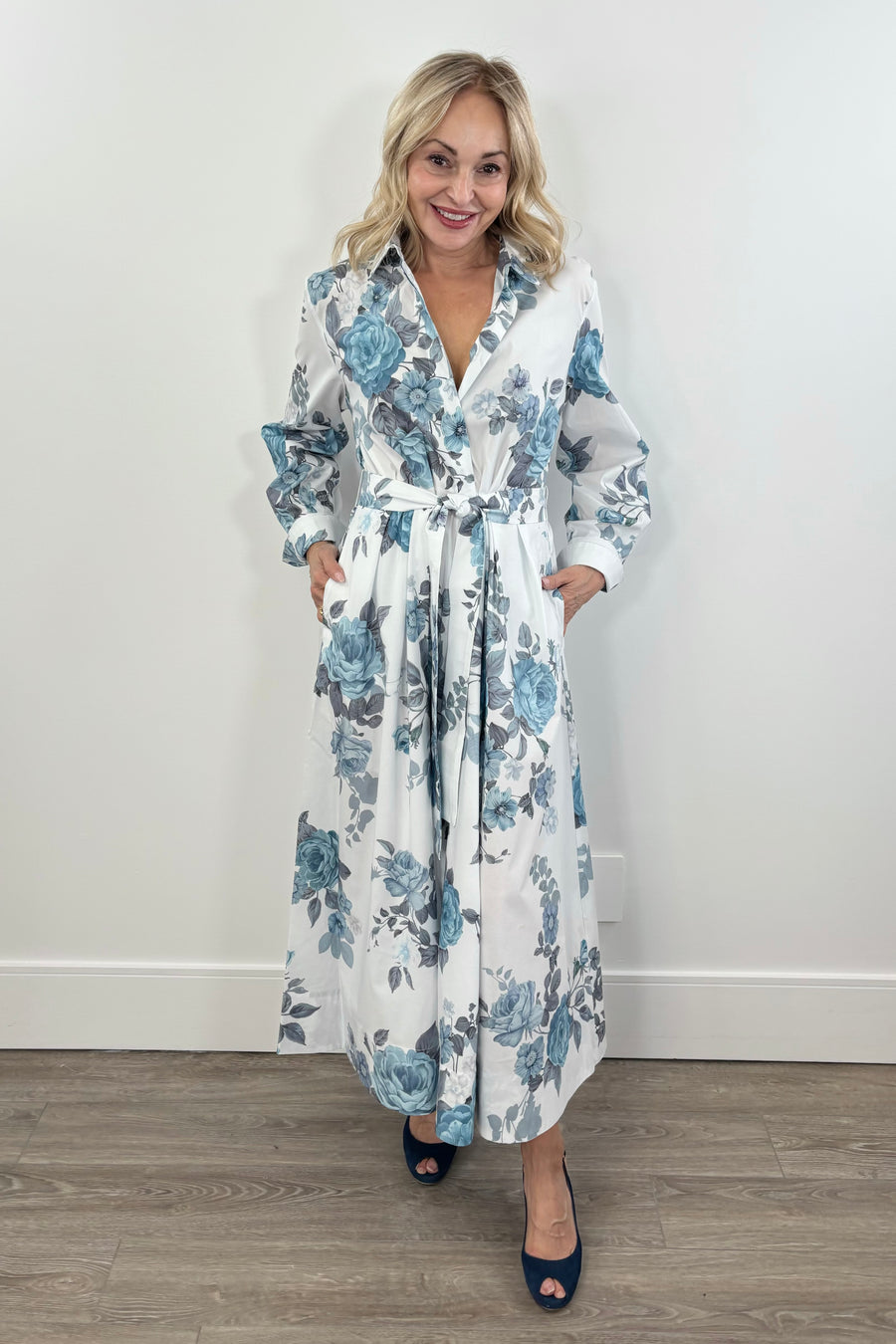 Woman wearing a white cotton dress with light blue floral print all over