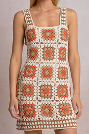 Close-up of an orange, white and beige patterned crochet short dress 
