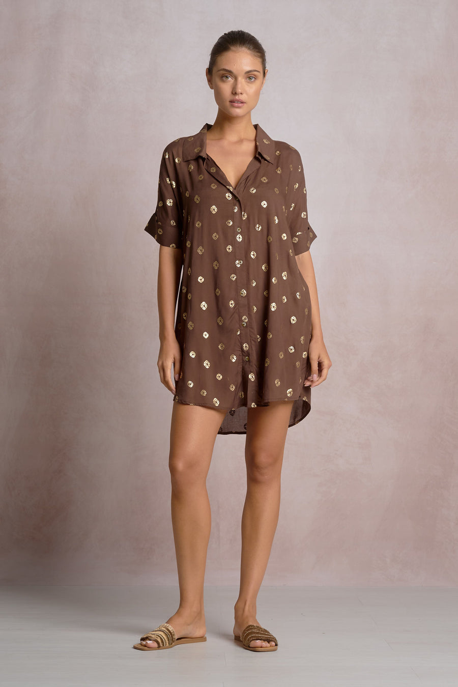 woman wearing a brown short shirt dress with gold detailing