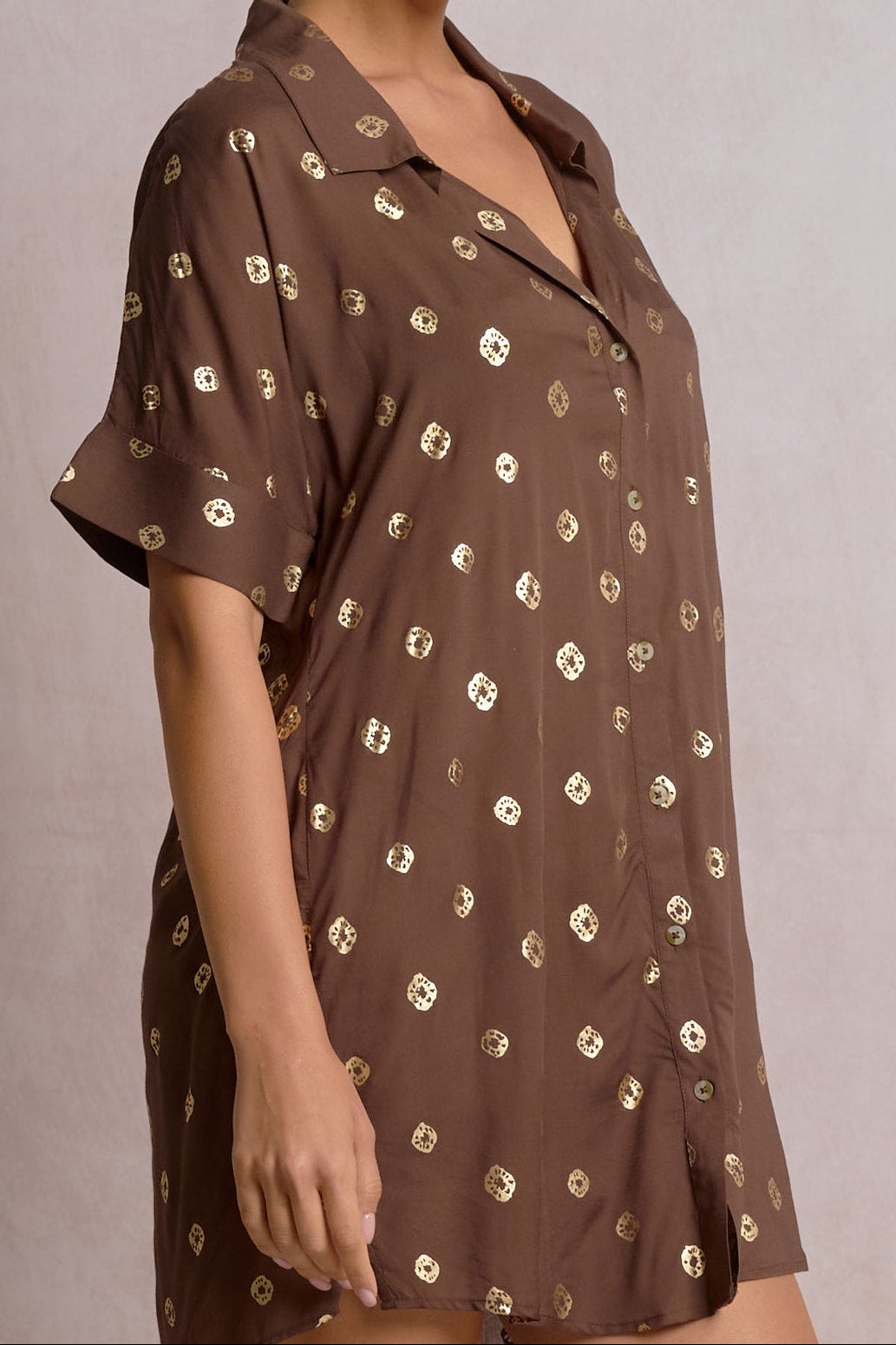 close-up of a brown short shirt dress with gold detailing