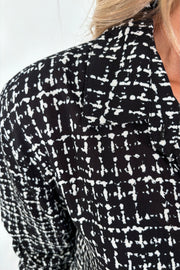 Close-up of the shoulder of a black and white grid patterned blouse