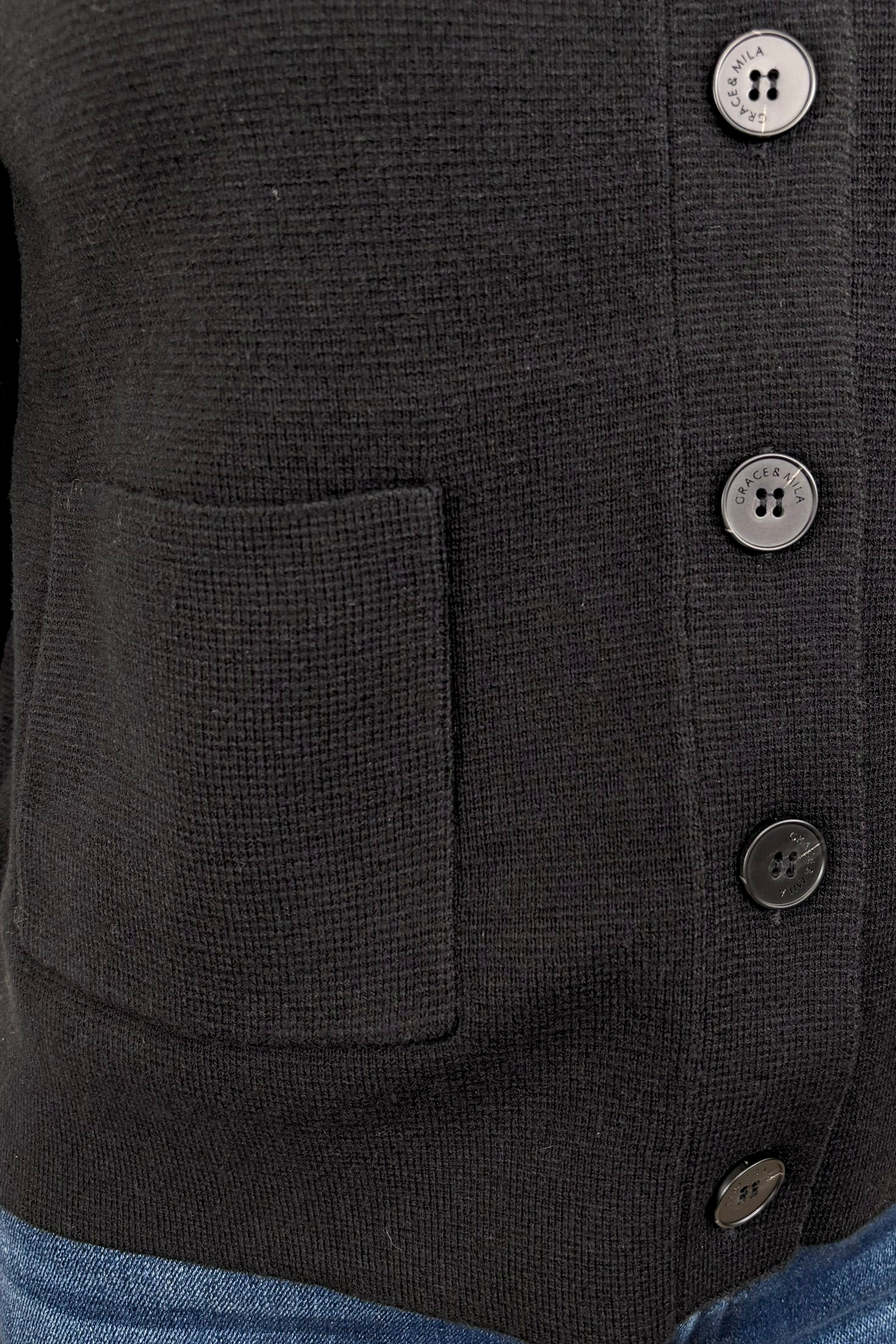 close up of black cardigan with pockets in the front