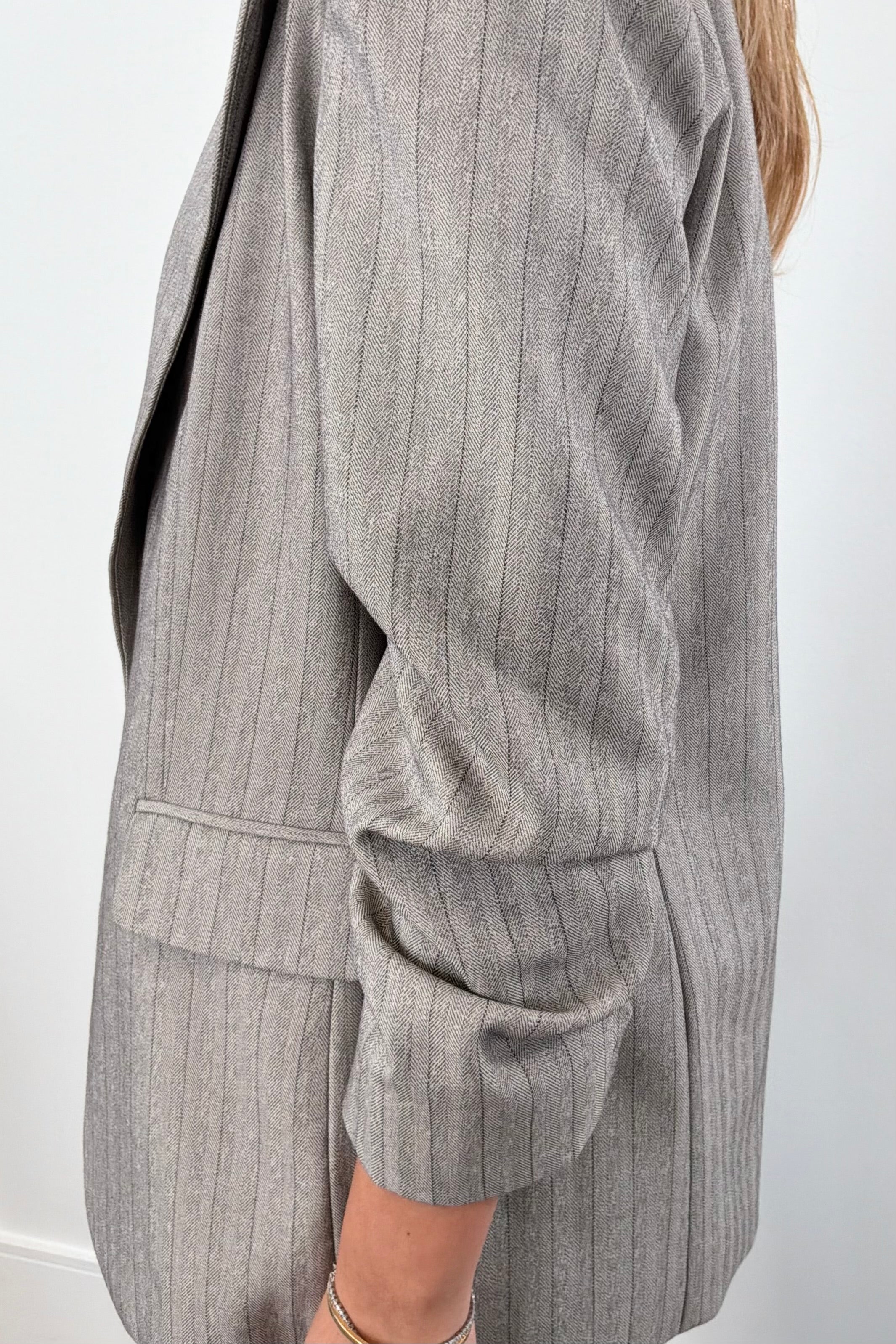 Woman wearing a gray pin stripe blazer