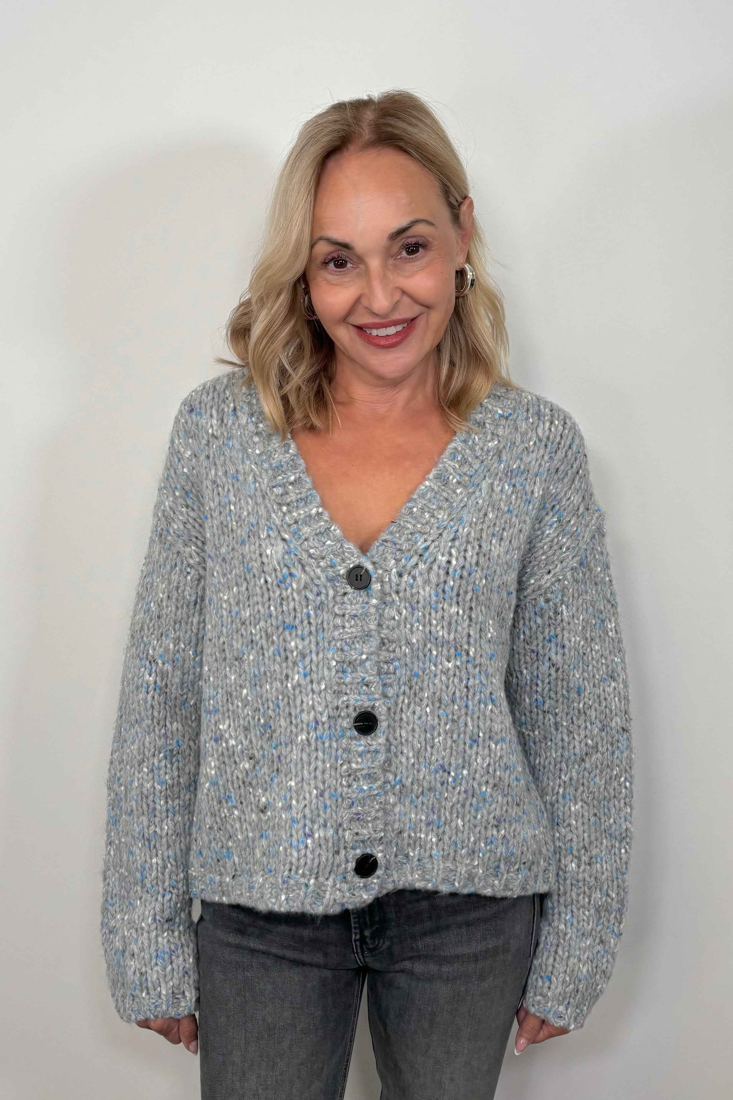 Front view of woman wearing an oversized gray and blue cardigan