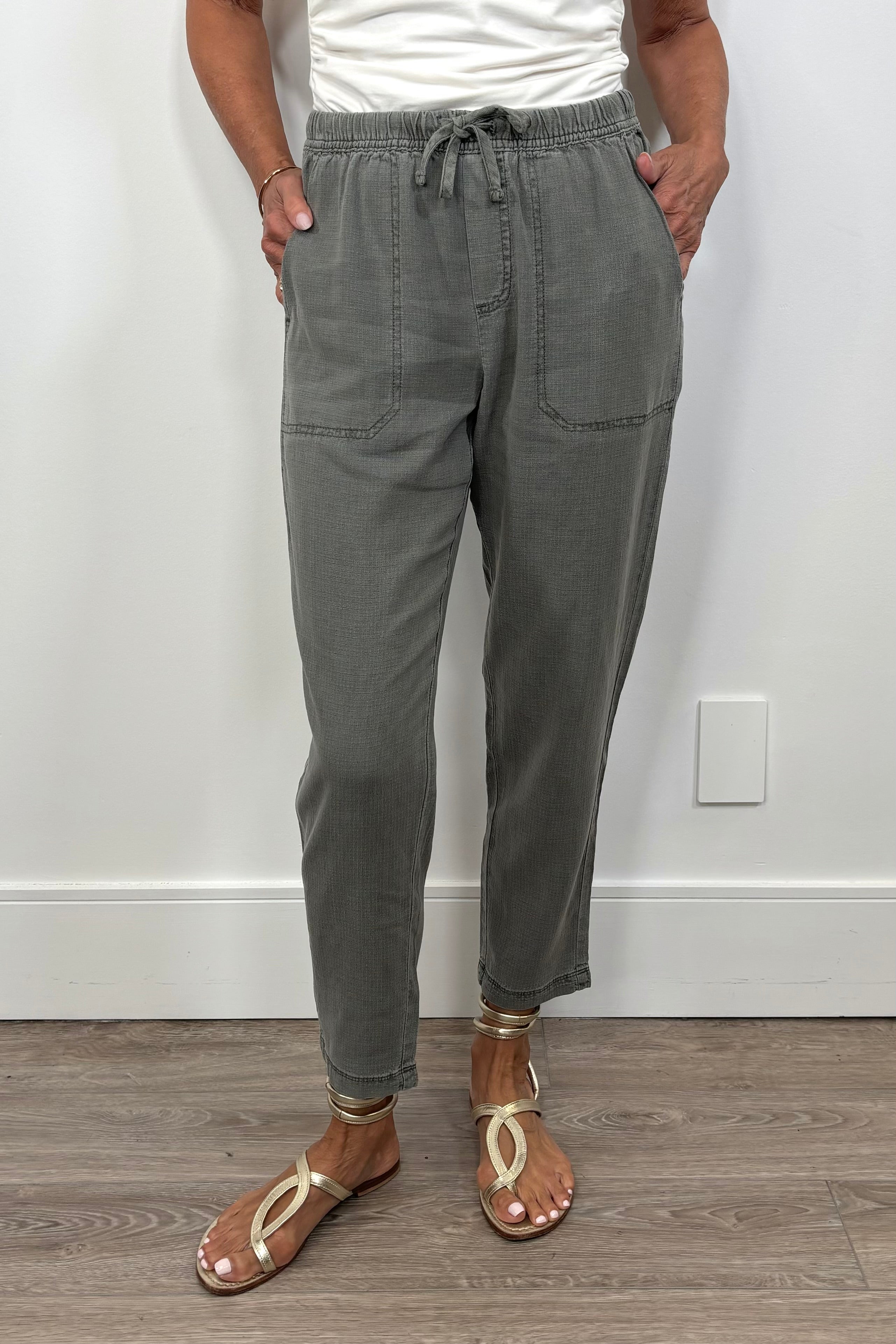 Front view of a woman wearing green straight leg pants