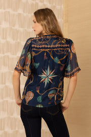 Back view of woman wearing a navy patterned silk blouse